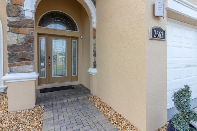 entrance to property featuring stucco siding and a garage