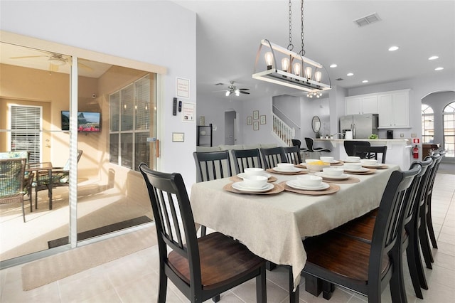 dining space with stairway, a ceiling fan, visible vents, recessed lighting, and arched walkways