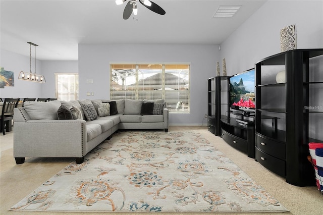 carpeted living area with visible vents, baseboards, and ceiling fan