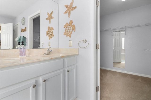 bathroom with a sink, baseboards, and double vanity