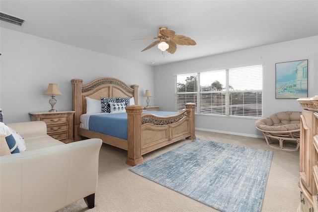 bedroom with ceiling fan, baseboards, visible vents, and light carpet