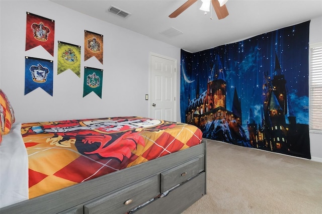 carpeted bedroom featuring an accent wall, a ceiling fan, and visible vents