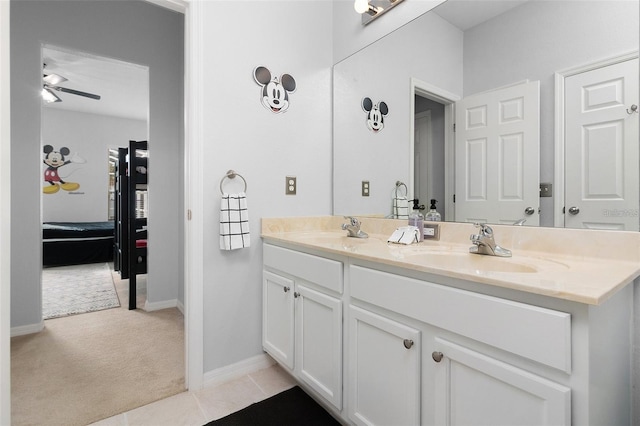 full bathroom featuring a sink, baseboards, double vanity, and tile patterned flooring