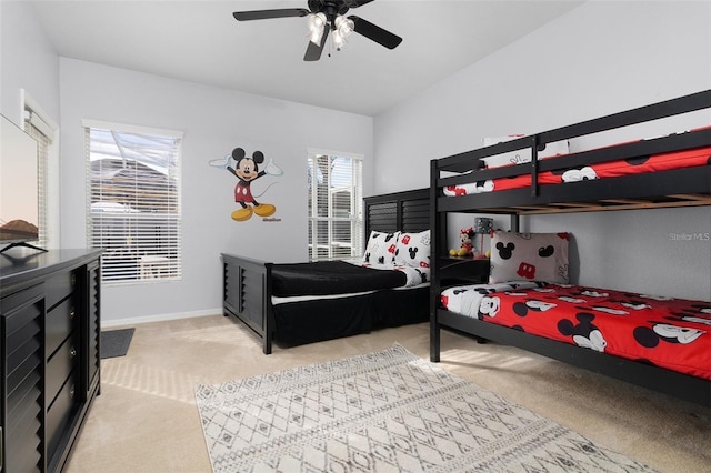 bedroom featuring multiple windows, light carpet, baseboards, and ceiling fan