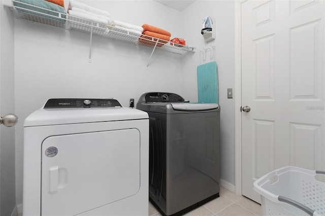 laundry area featuring light tile patterned floors, laundry area, and washing machine and dryer