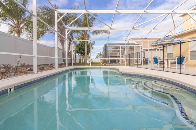 view of swimming pool with a patio area, a fenced in pool, a lanai, and fence