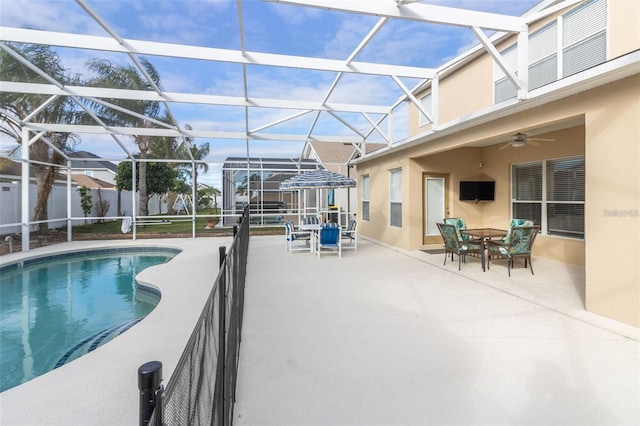 view of pool with outdoor dining space, a patio, a ceiling fan, a fenced in pool, and a lanai