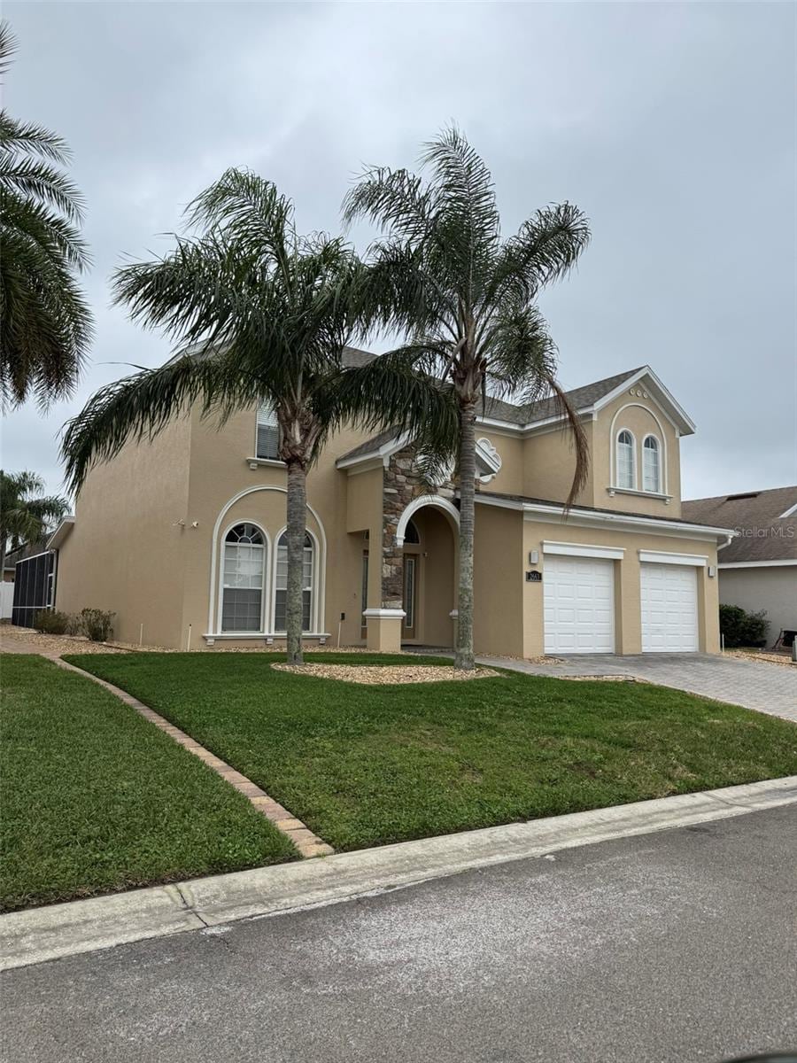 2663 Sand Hill Point Cir, Davenport, FL 33837 - view of front of home with stucco siding, driveway, a front lawn, and a garage