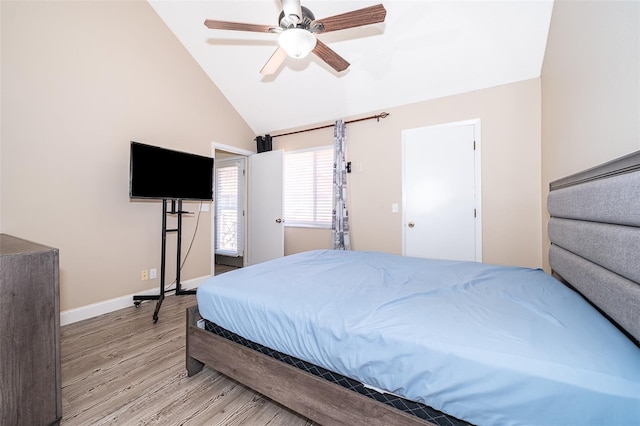 bedroom with lofted ceiling, light wood finished floors, a ceiling fan, and baseboards