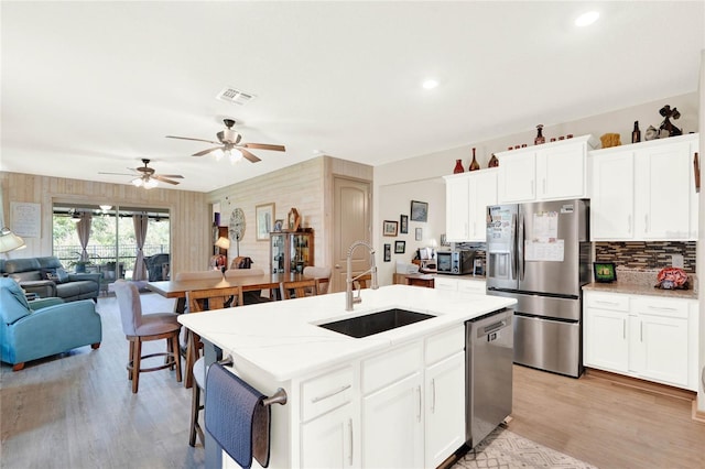 kitchen featuring visible vents, light wood-type flooring, a sink, open floor plan, and appliances with stainless steel finishes