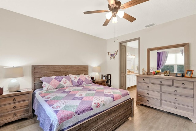 bedroom with ceiling fan, light wood-style flooring, visible vents, and connected bathroom