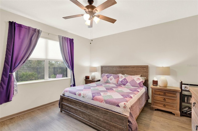 bedroom with baseboards, ceiling fan, and wood finished floors