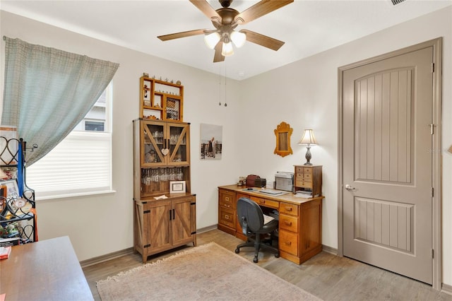 office with baseboards, a ceiling fan, and light wood finished floors