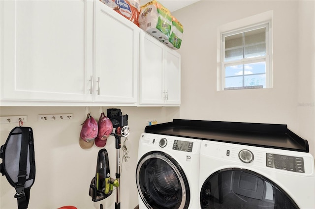 washroom featuring cabinet space and washing machine and dryer