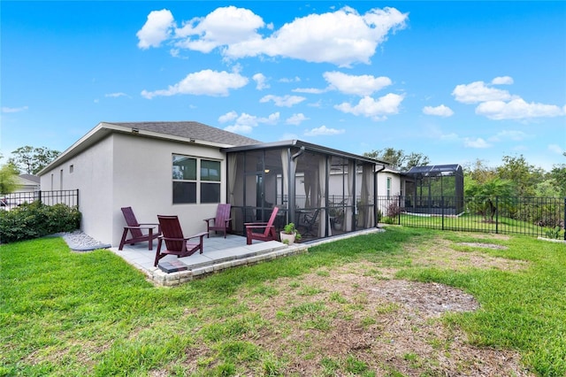 back of property with a fenced backyard, a sunroom, stucco siding, a patio area, and a lawn