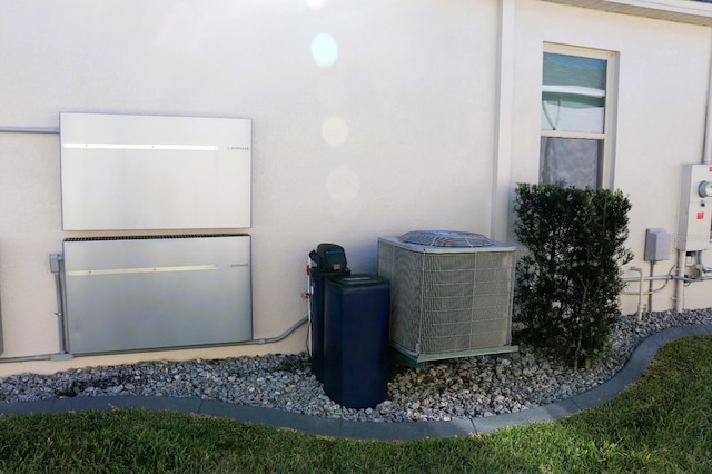 exterior details with stucco siding and central AC