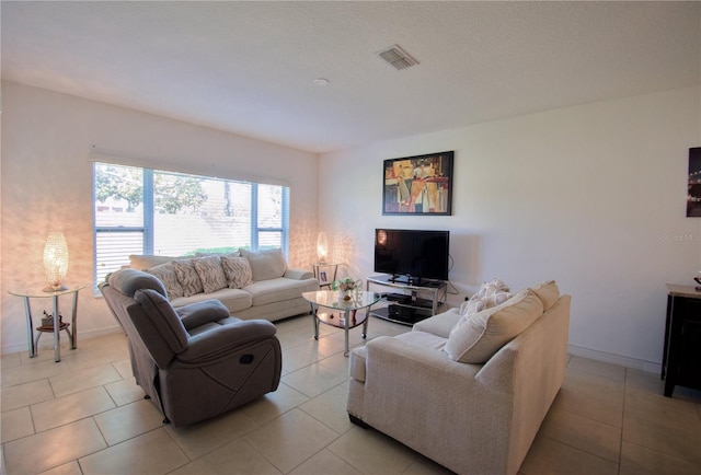 living room featuring light tile patterned flooring, visible vents, and baseboards