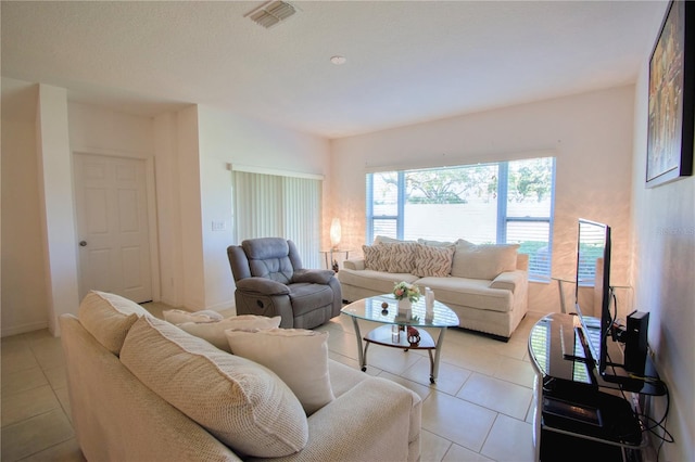 living room with light tile patterned floors, visible vents, and baseboards