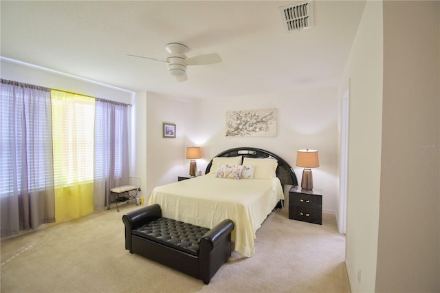 carpeted bedroom featuring visible vents and a ceiling fan