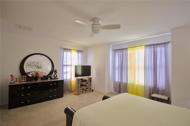 carpeted bedroom featuring ceiling fan and visible vents