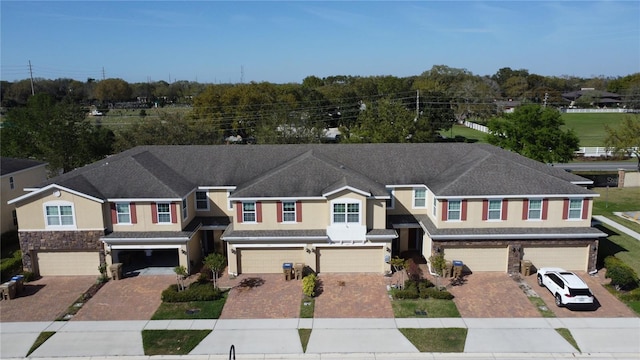 view of front of house featuring driveway, an attached garage, and stucco siding