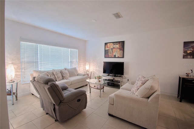 living area with light tile patterned floors, visible vents, and baseboards