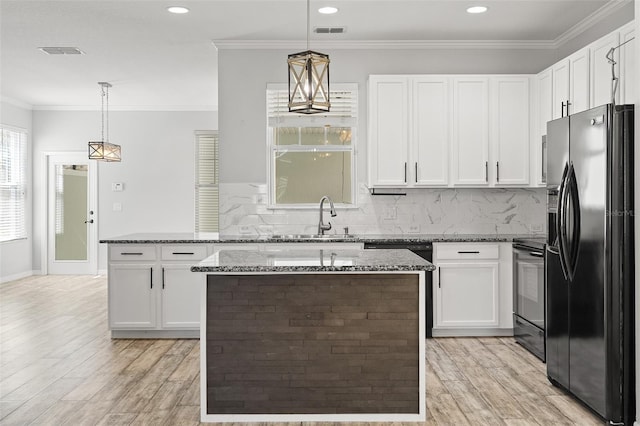 kitchen with black appliances, ornamental molding, a sink, and visible vents