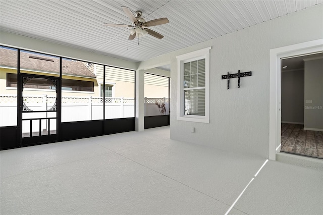 unfurnished sunroom featuring a ceiling fan