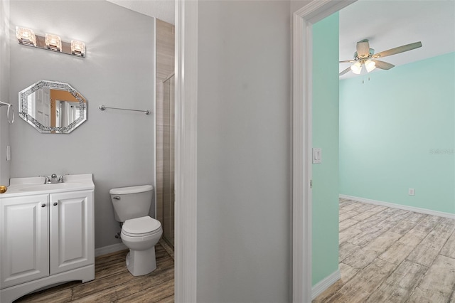 full bath featuring vanity, wood finished floors, toilet, and baseboards