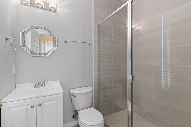 bathroom featuring a stall shower, vanity, and toilet