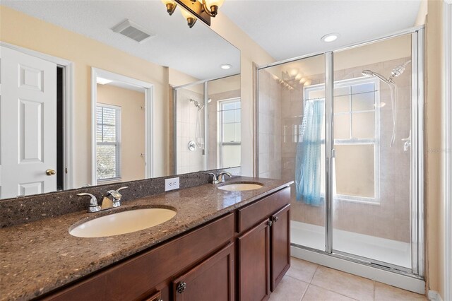 bathroom featuring a stall shower, tile patterned flooring, and a sink