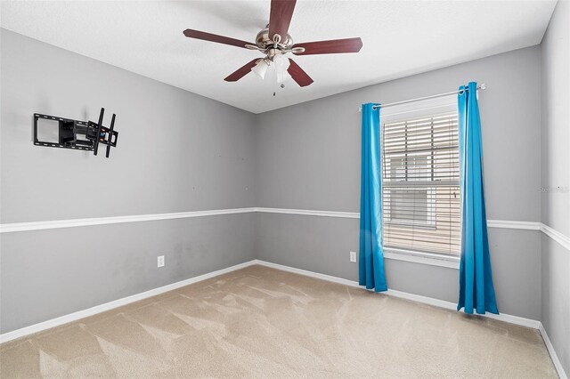 spare room featuring carpet floors, ceiling fan, and baseboards