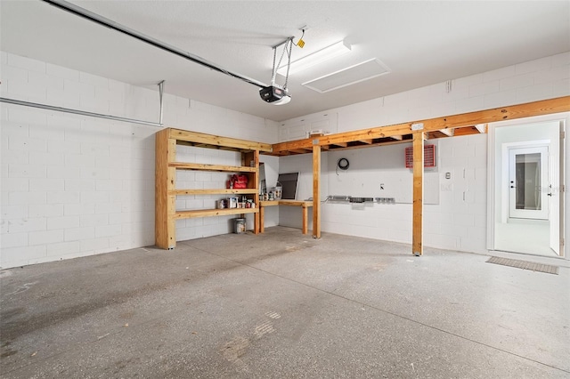 garage with concrete block wall and a garage door opener