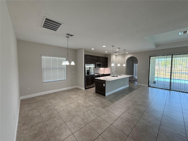 kitchen featuring open floor plan, arched walkways, visible vents, and appliances with stainless steel finishes