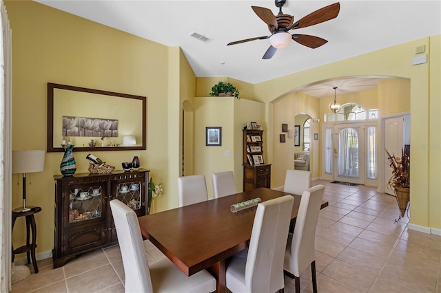 dining room featuring arched walkways, light tile patterned floors, visible vents, baseboards, and ceiling fan with notable chandelier