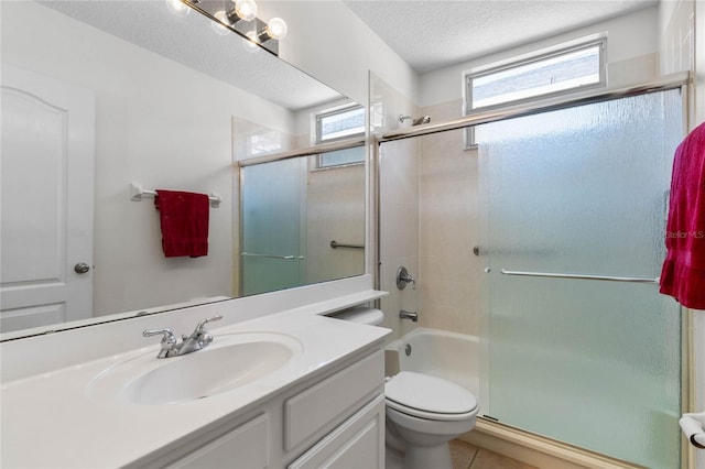 bathroom with a textured ceiling, vanity, toilet, and tile patterned floors