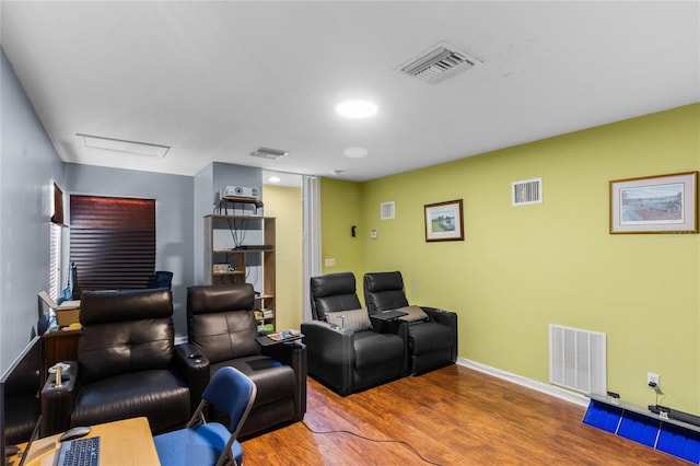 home theater room with wood finished floors and visible vents