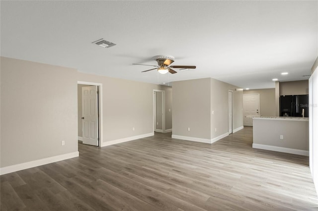 unfurnished living room with visible vents, baseboards, and wood finished floors