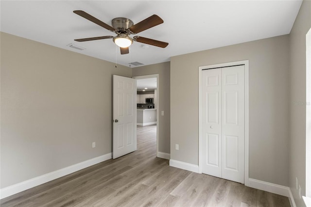 unfurnished bedroom featuring light wood-style floors, baseboards, and visible vents