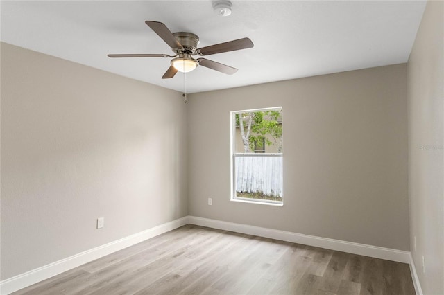 empty room featuring light wood-style floors, baseboards, and a ceiling fan