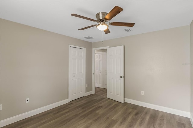 unfurnished bedroom with baseboards, visible vents, a ceiling fan, wood finished floors, and a closet