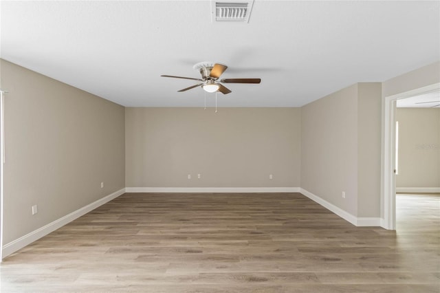 empty room featuring light wood-style floors, visible vents, ceiling fan, and baseboards