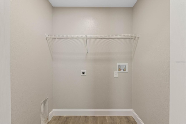 laundry area with laundry area, baseboards, light wood-style flooring, washer hookup, and electric dryer hookup