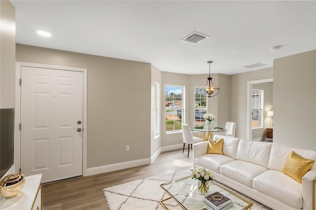 living area with baseboards, visible vents, and light wood finished floors