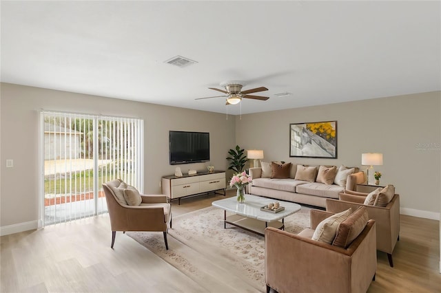 living area with light wood-style floors, visible vents, baseboards, and a ceiling fan