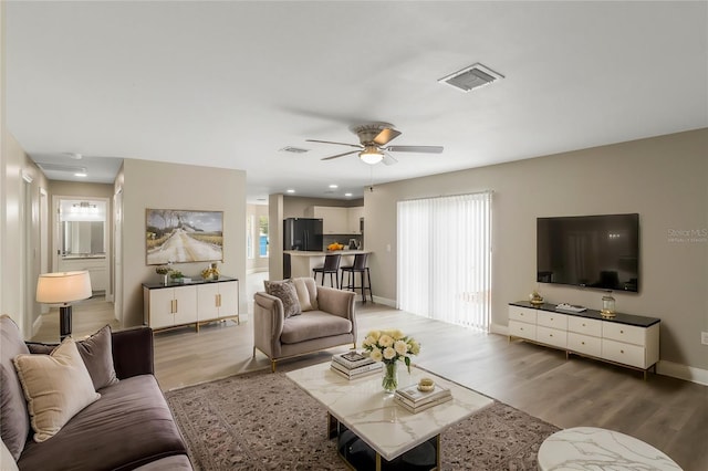 living area with a wealth of natural light, wood finished floors, and visible vents