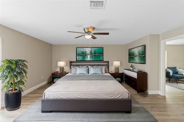 bedroom with baseboards, visible vents, ceiling fan, and light wood finished floors