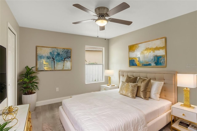 bedroom featuring a ceiling fan, baseboards, and wood finished floors