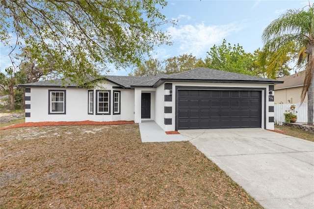 ranch-style home with an attached garage, fence, concrete driveway, roof with shingles, and stucco siding