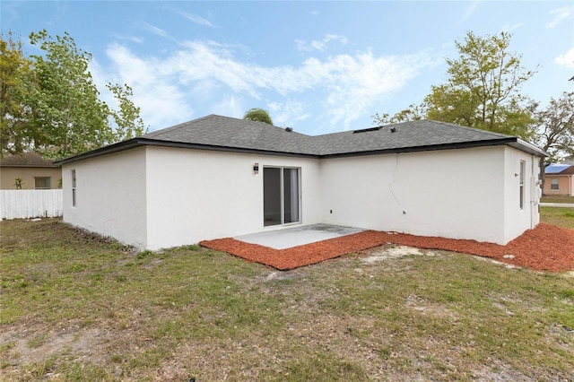 back of property featuring a yard, a patio, stucco siding, a shingled roof, and fence